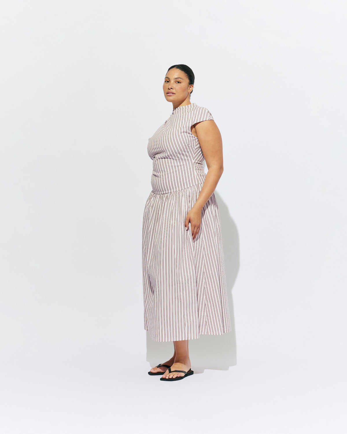 BIRDIE MAXI DRESS PINK LADY STRIPE | Drop waist maxi dress designed in our organic cotton pink lady stripe. Featuring a high neck collar, pleated skirt and a gather detail on the lower back designed for better fit and movement. Layer with one of our Blazers for...