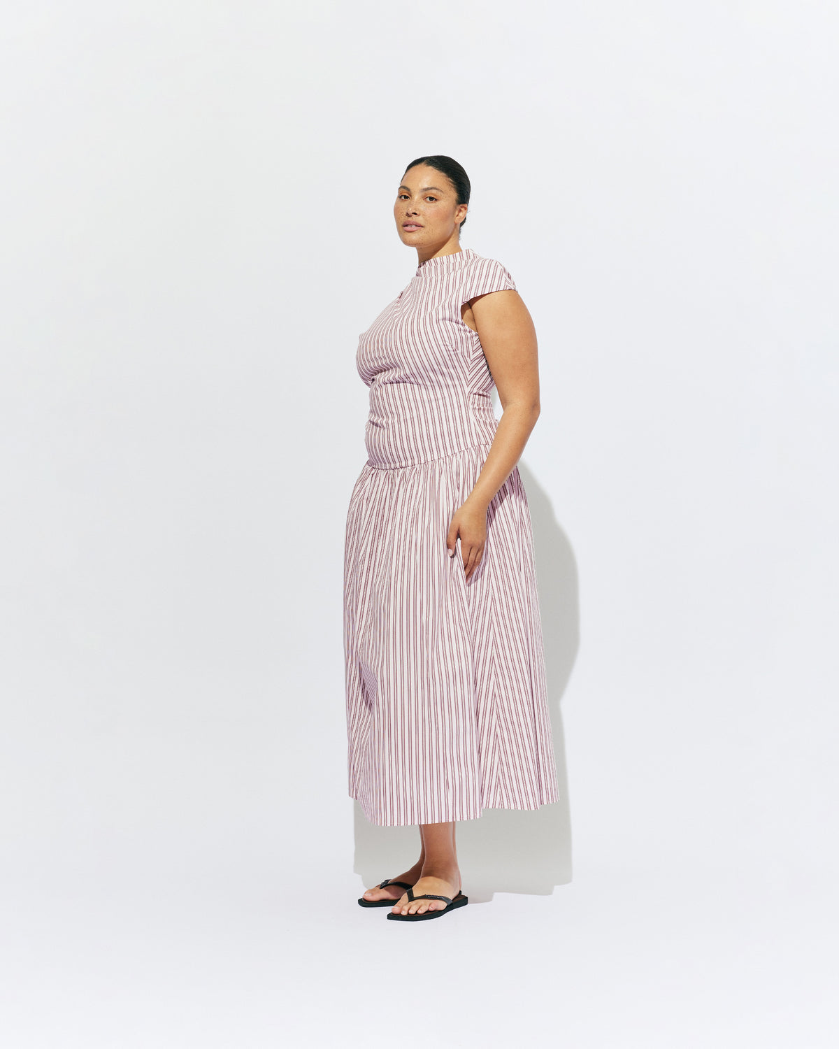 BIRDIE MAXI DRESS PINK LADY STRIPE | Drop waist maxi dress designed in our organic cotton pink lady stripe. Featuring a high neck collar, pleated skirt and a gather detail on the lower back designed for better fit and movement. Layer with one of our Blazers for...