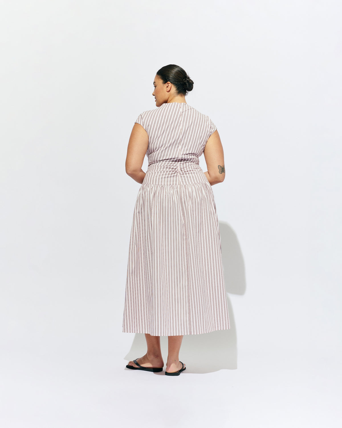 BIRDIE MAXI DRESS PINK LADY STRIPE | Drop waist maxi dress designed in our organic cotton pink lady stripe. Featuring a high neck collar, pleated skirt and a gather detail on the lower back designed for better fit and movement. Layer with one of our Blazers for...