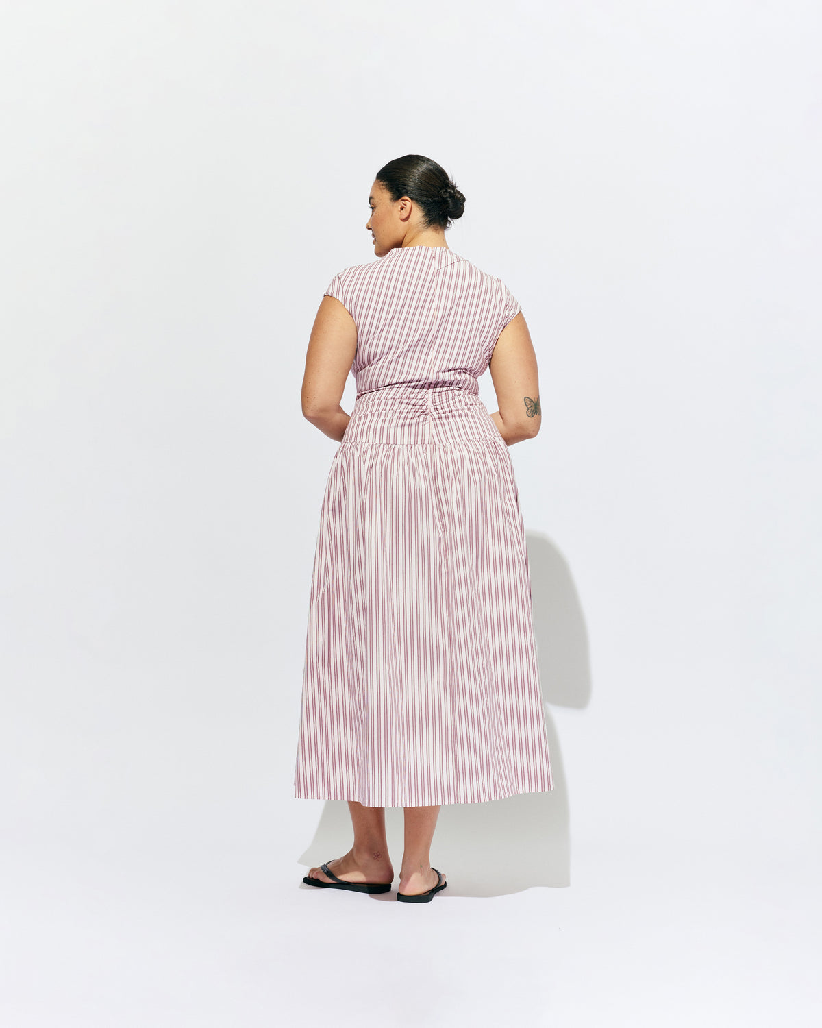 BIRDIE MAXI DRESS PINK LADY STRIPE | Drop waist maxi dress designed in our organic cotton pink lady stripe. Featuring a high neck collar, pleated skirt and a gather detail on the lower back designed for better fit and movement. Layer with one of our Blazers for...