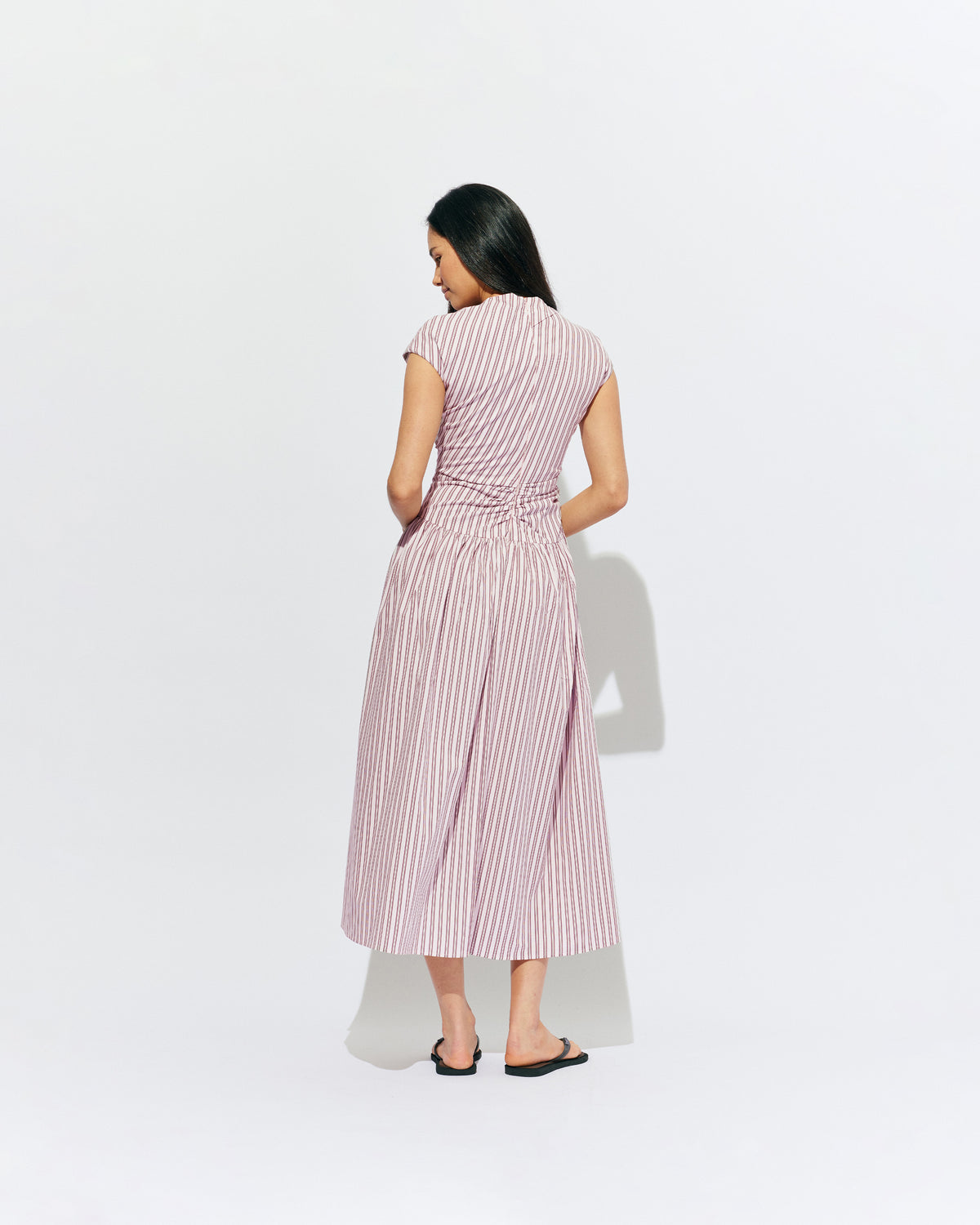 BIRDIE MAXI DRESS PINK LADY STRIPE | Drop waist maxi dress designed in our organic cotton pink lady stripe. Featuring a high neck collar, pleated skirt and a gather detail on the lower back designed for better fit and movement. Layer with one of our Blazers for...