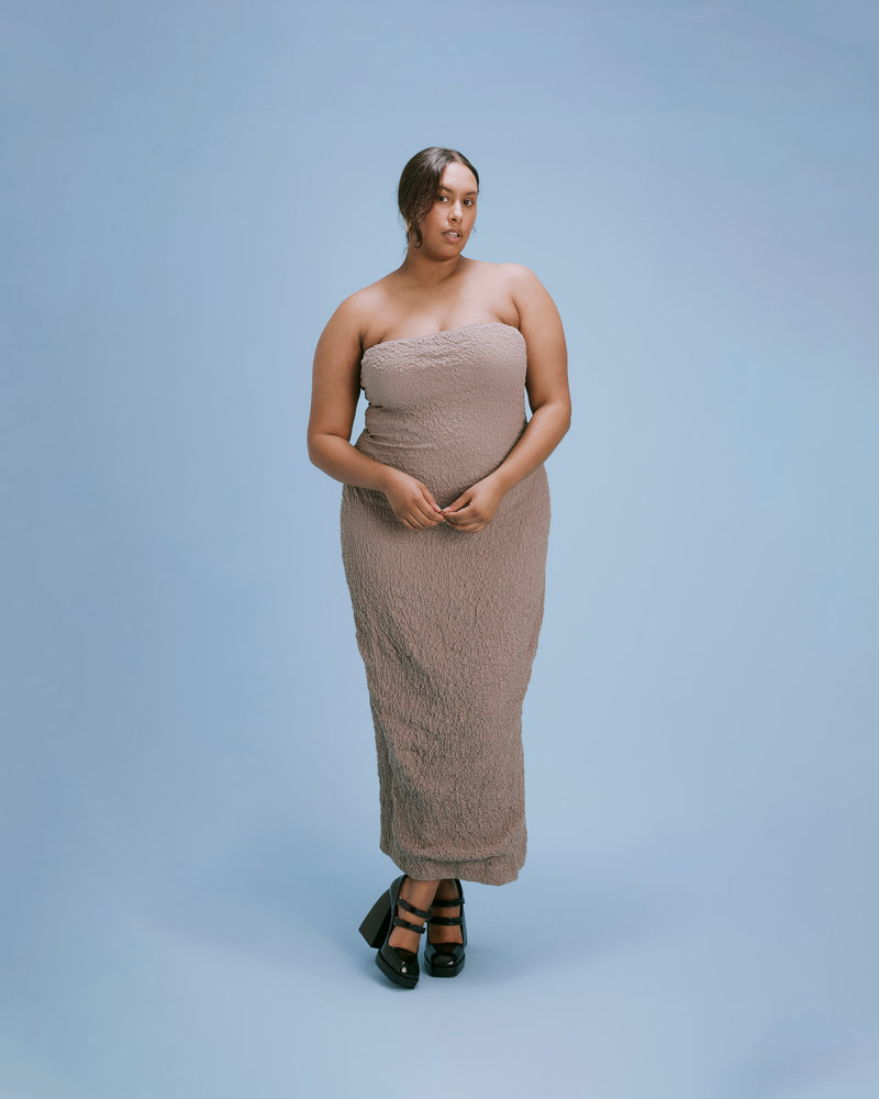 BUBBLE DRESS TAUPE | Fitted strapless midi dress with a split at the back allowing for ease of movement. Woven into a tactile story as reflected in its name, the textured element adds a...