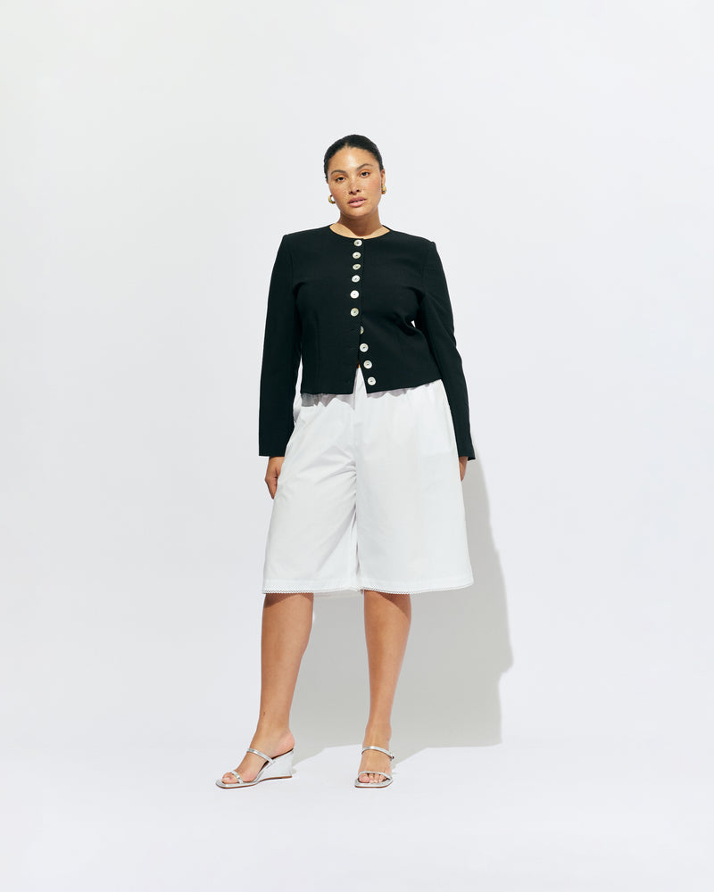 CAROLYN BLAZER BLACK | Collarless long sleeve black blazer with feature pearlescent buttons.  An elevated classic with a structured silhouette, this top is the perfect addition to your everyday workwear rotation. Pair with your favourite trousers, or denim for a more casual look.