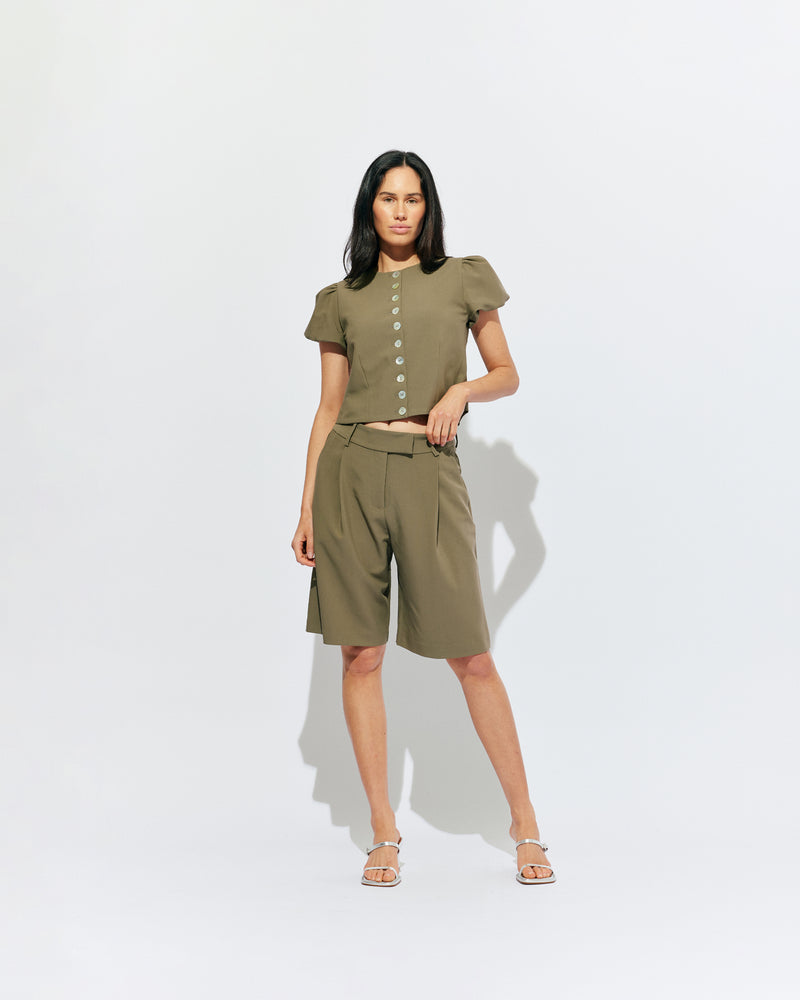 CAROLYN PUFF SLEEVE BLAZER MARTINI OLIVE | Collarless short sleeve blazer with feature pearlescent buttons and puff sleeves.  An elevated classic with a structured silhouette, this top is the perfect addition to your everyday workwear rotation. Pair with our Coco Suit Short for a matching moment, or...