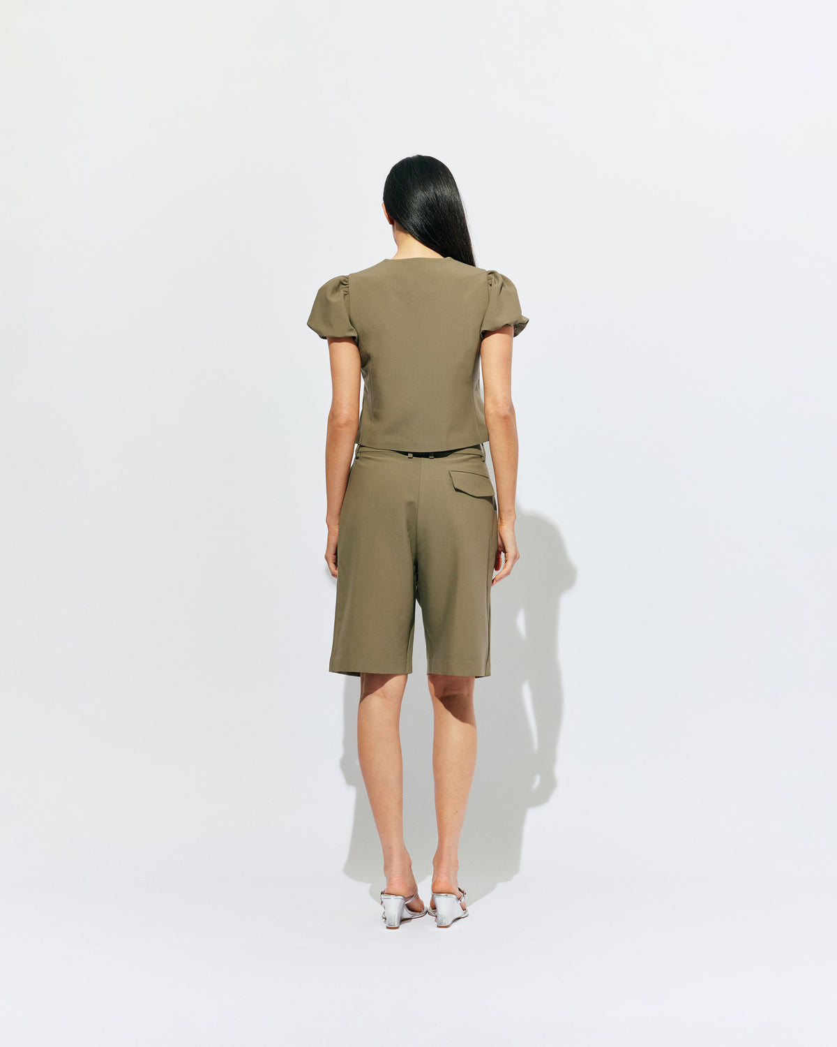 CAROLYN PUFF SLEEVE BLAZER MARTINI OLIVE | Collarless short sleeve blazer with feature pearlescent buttons and puff sleeves.  An elevated classic with a structured silhouette, this top is the perfect addition to your everyday workwear rotation. Pair with our Coco Suit Short for a matching moment, or...