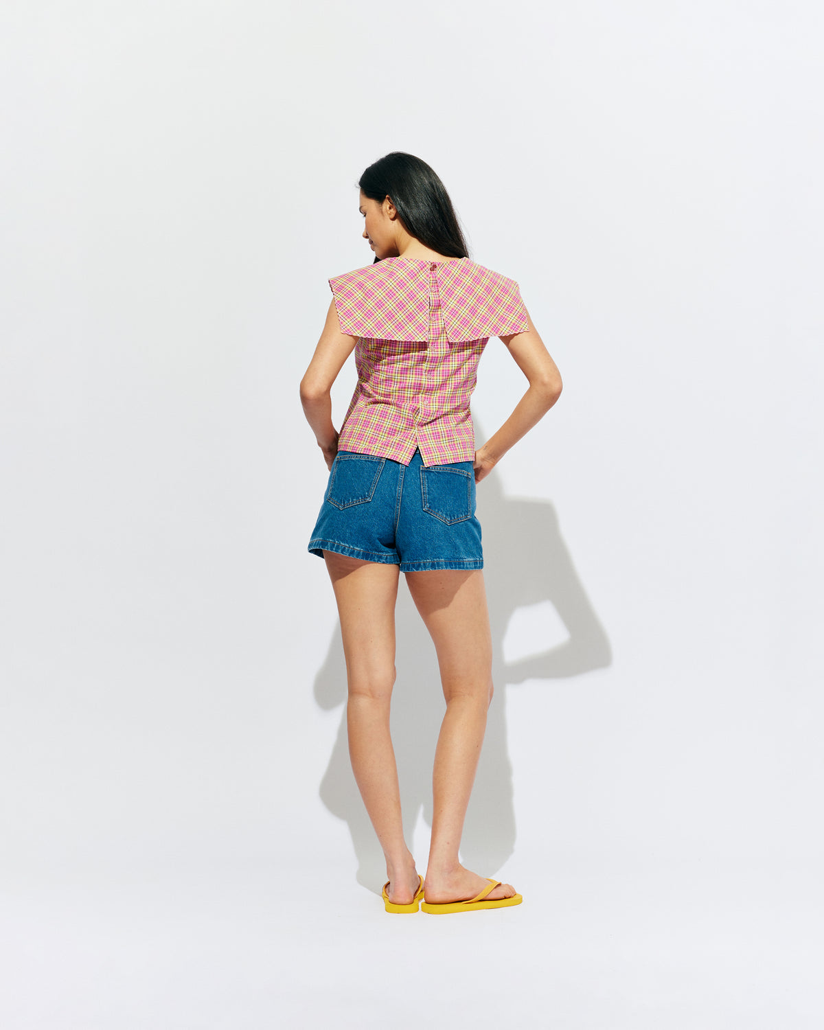 CRUSH BLOUSE PINK YELLOW TARTAN | Sleeveless blouse featuring an oversized sailor-style collar with a scalloped hem and broderie detailing on the sides, designed in our organic cotton pink yellow tartan. Features a button up design at the back, which can be worn open to keep...