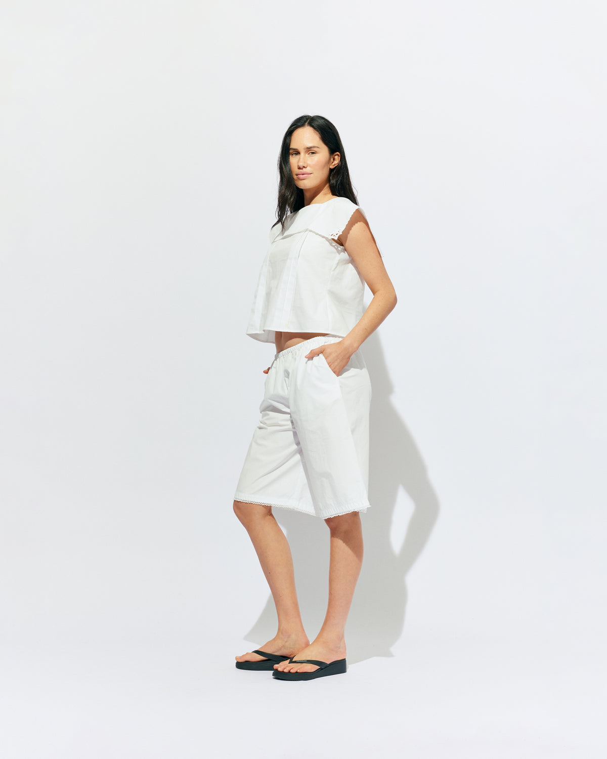 CRUSH BLOUSE WHITE | Sleeveless blouse featuring an oversized sailor-style collar with a scalloped hem and broderie detailing on the sides, designed in our classic white organic cotton. Features a button up design at the back, which can be worn open to keep you...