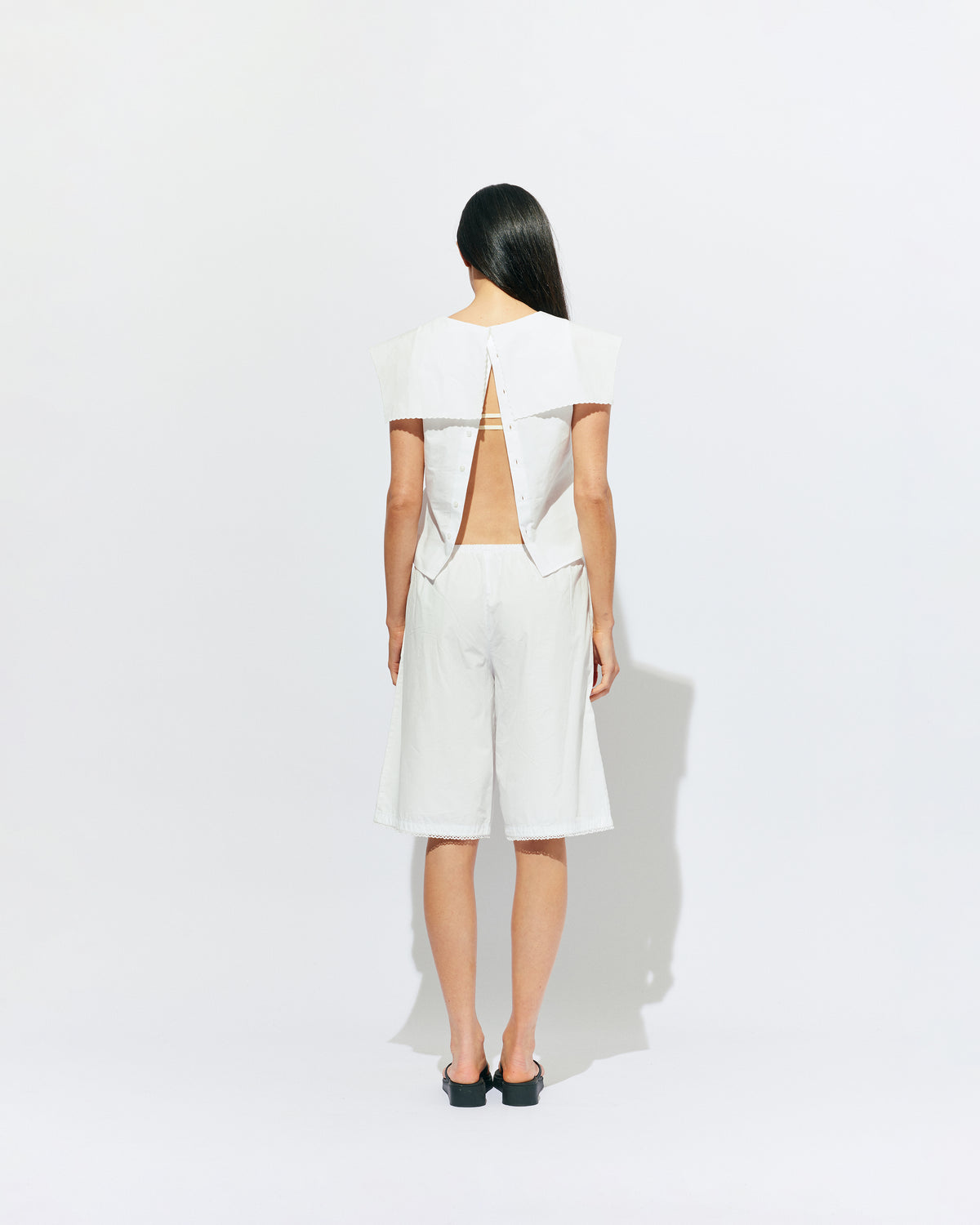 CRUSH BLOUSE WHITE | Sleeveless blouse featuring an oversized sailor-style collar with a scalloped hem and broderie detailing on the sides, designed in our classic white organic cotton. Features a button up design at the back, which can be worn open to keep you...