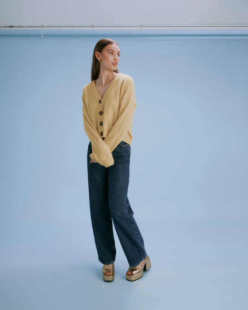 DARCY CARDIGAN BANANA | Relaxed fit cardigan defined by ribbed trims with a slightly cropped hem. With four square tortoiseshell buttons, this piece can be worn undone as a layering piece or buttoned up...