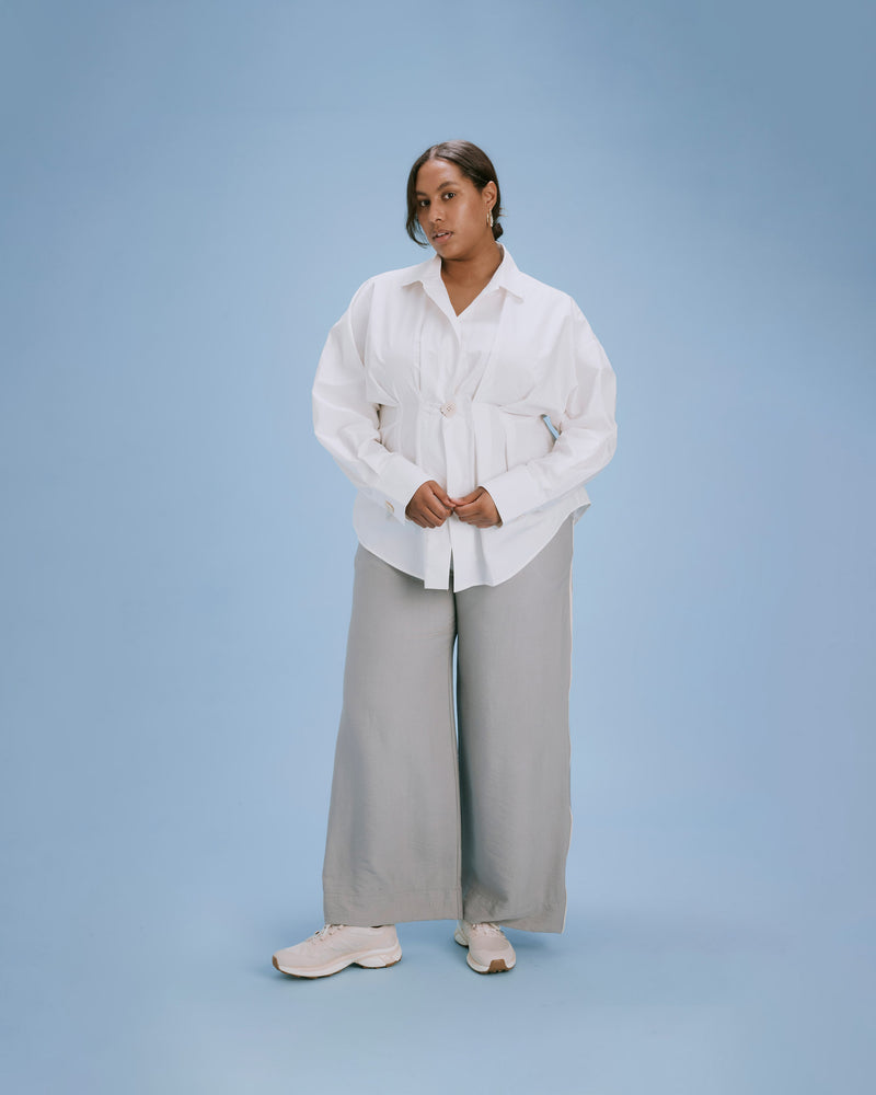 FIONA PLEAT SHIRT WHITE | Longsleeve shirt in a structured silhouette that is nipped in at the waist with a large square button. Cuffed longsleeves, a yoke line and a pointed collar create a tailored...