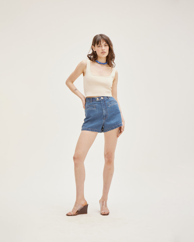 SUZIE DENIM SHORT INDIGO | Fitted highwaist short with a double button closure detail and slightly flared hem in a indigo denim. Small features such as an asymmetrical seam across the back and wide seam...