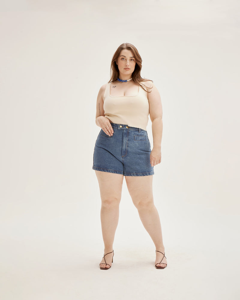 SUZIE DENIM SHORT INDIGO | Fitted highwaist short with a double button closure detail and slightly flared hem in a indigo denim. Small features such as an asymmetrical seam across the back and wide seam...