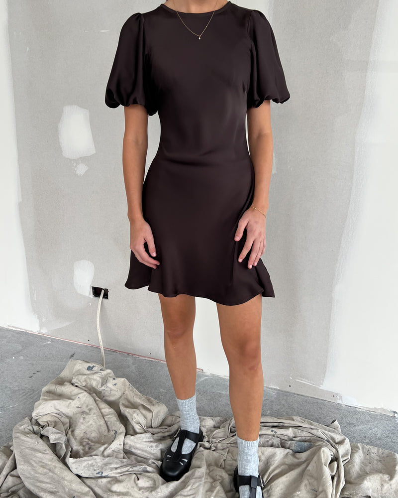 KENDALL SATIN MINIDRESS ESPRESSO | Bias cut satin minidress with puff sleeves and a keyhole button closure at the back neck. The bias silhouette of this dress gently contours the body.