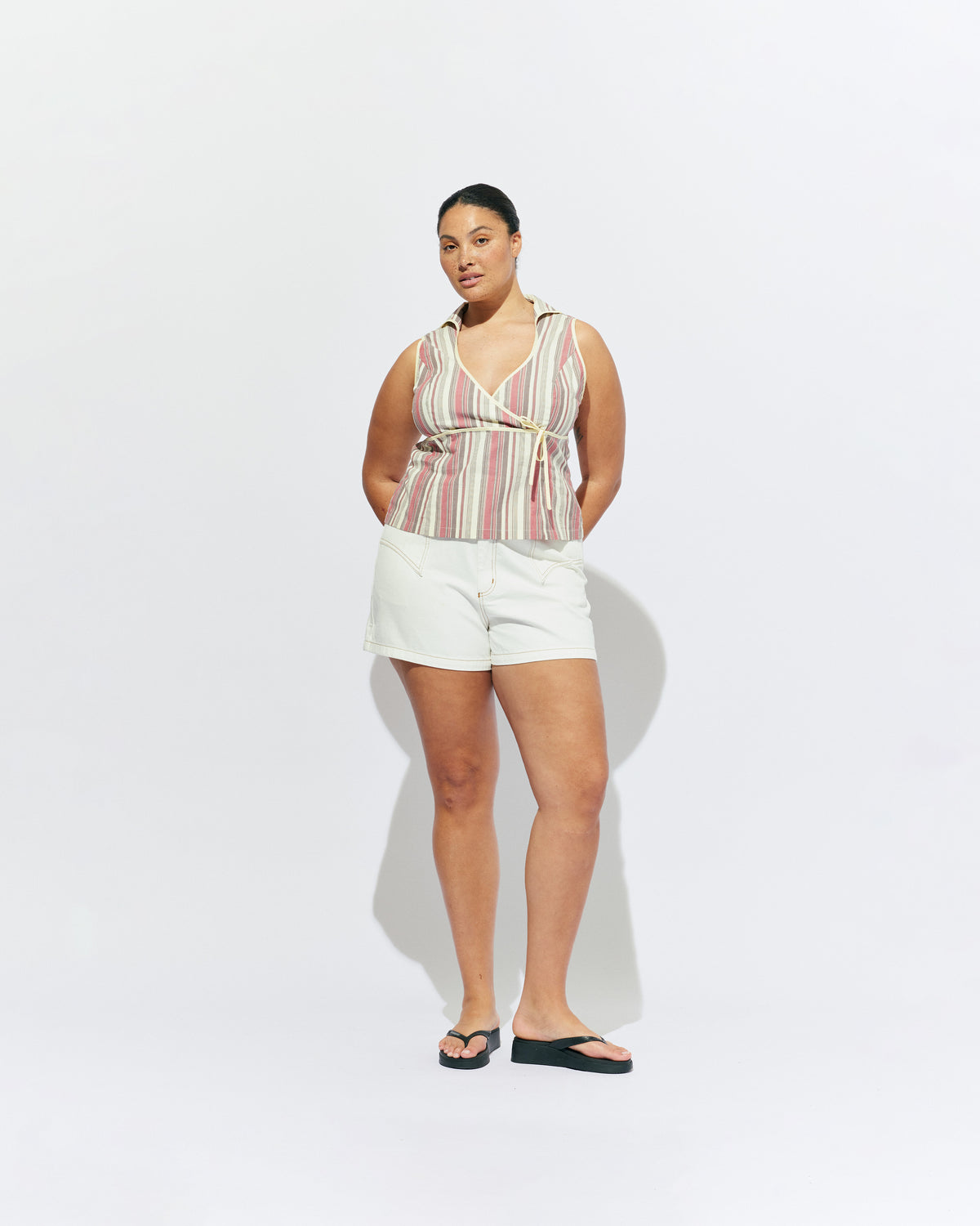 JOEY TOP ANASE STRIPE | Sleeveless fitted top with an oversized keyhole-style neckline, crafted in our anase stripe organic cotton. Features contrast binding along the seams, a crossover bust and an attached waist tie. Make it a matching set with our Sonny Pant, or pair...