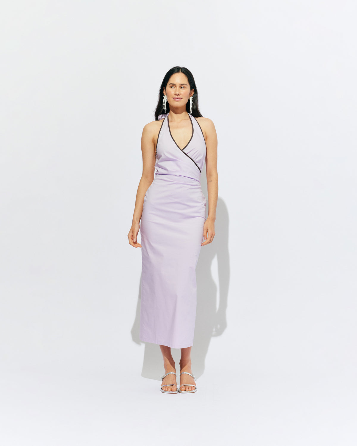 JOEY DRESS LILAC | Bias cut midi dress with a tie-up halter neckline, crafted in our lilac organic cotton. Designed with ruching details on the waist and back for a tailored fit through the body, which falls into a straight cut skirt with a...