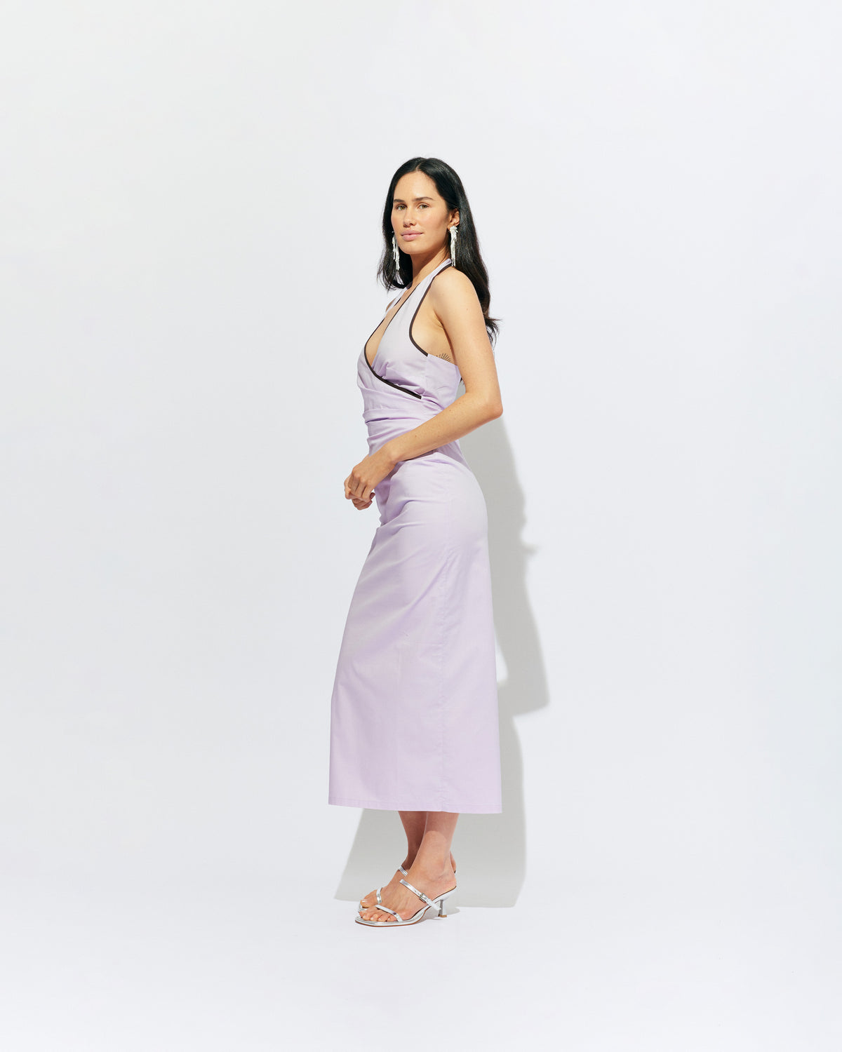 JOEY DRESS LILAC | Bias cut midi dress with a tie-up halter neckline, crafted in our lilac organic cotton. Designed with ruching details on the waist and back for a tailored fit through the body, which falls into a straight cut skirt with a...