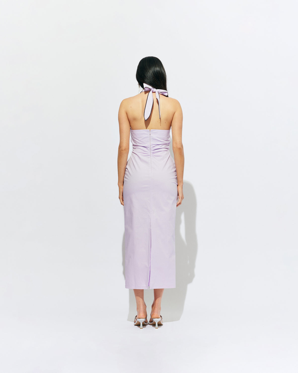 JOEY DRESS LILAC | Bias cut midi dress with a tie-up halter neckline, crafted in our lilac organic cotton. Designed with ruching details on the waist and back for a tailored fit through the body, which falls into a straight cut skirt with a...