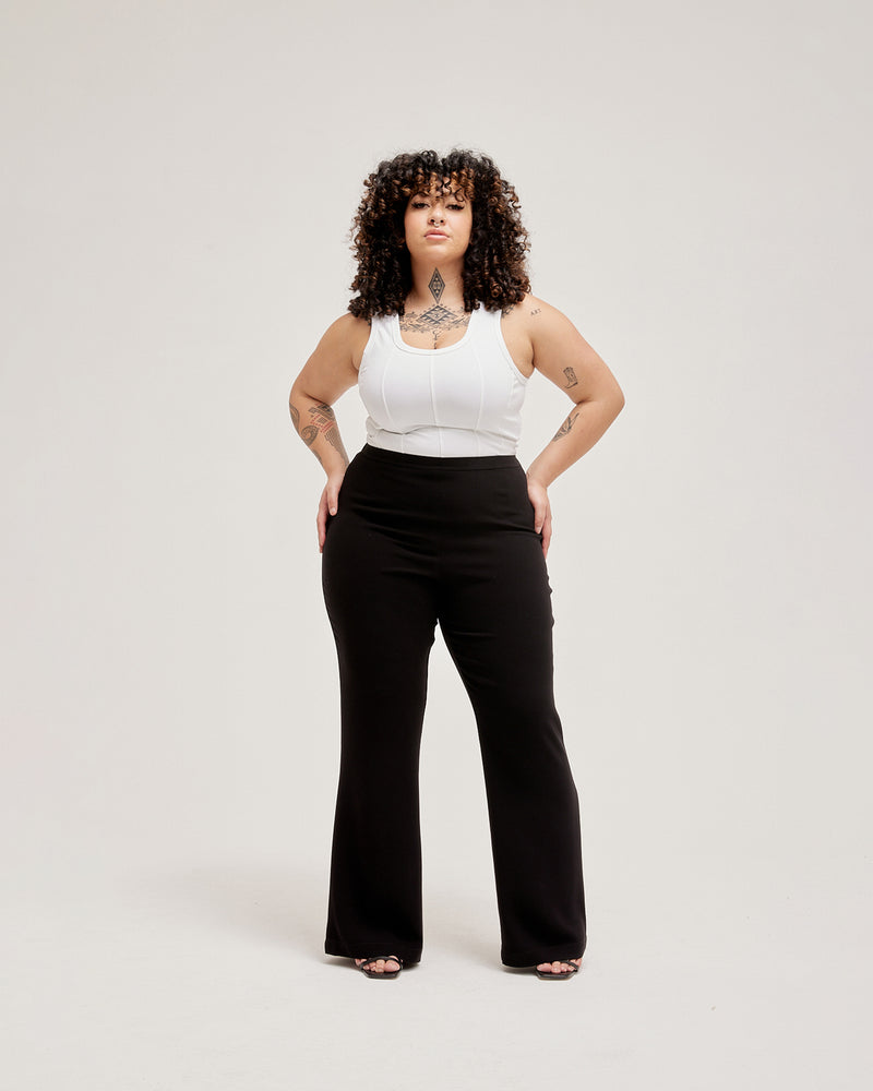 POPPY PANT PETITE BLACK | Highwaisted pant that sits snug at the waist, hip and thigh and falls to a subtle flare designed in a black crepe fabric. These pants are timeless and tailored to...