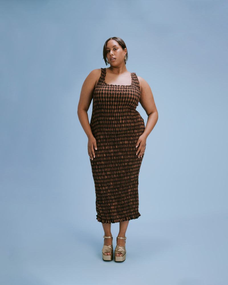 KLEIN GINGHAM MIDI DRESS CHOCOLATE CHECK | Shirred midi dress with a scoop neckline and ruffle hem detail in a neutral toned gingham. The shirring adds texture to the piece while also ensuring it fits closely to...