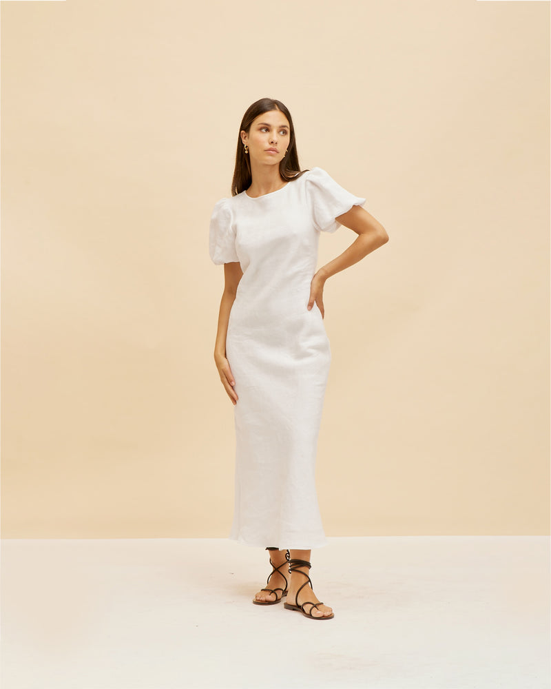 KOS LINEN DRESS WHITE | Bias cut dress with a subtle puff sleeve and cut out back with neck-ties. Cut in a white linen, this piece is designed to perfectly skim over your body, while...