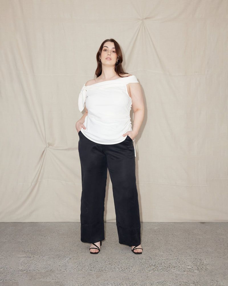 LILY OFF THE SHOULDER TOP WHITE | Asymmetrical off-shoulder top with a feature tie at the right shoulder. The side seam drawstring detail is designed to create gathered detailing across the body.