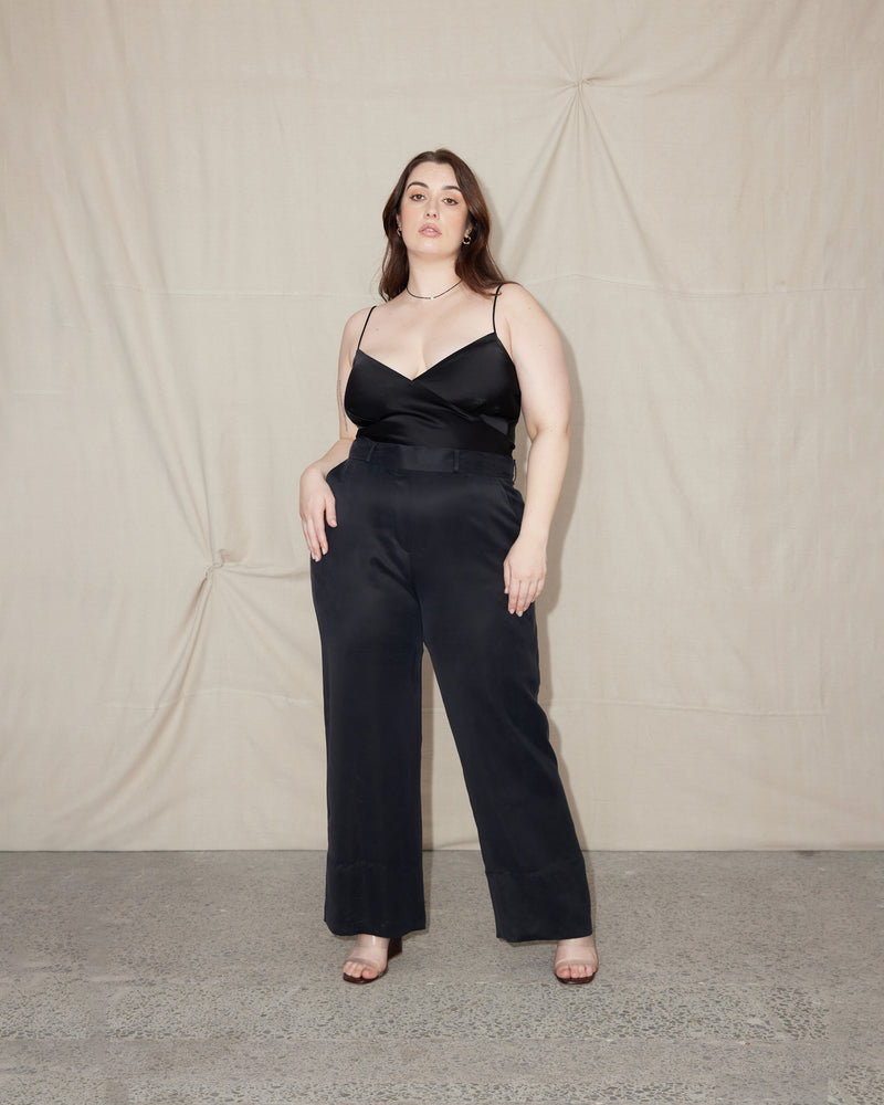 LIL' WEIRDLY BLACK | Bias-cut cropped camisole with adjustable shoestring straps. It features a V-neckline and has a soft silky texture with slight stretch. Style this cami as a layering piece over shirts, under...