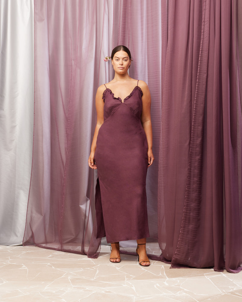 DELILAH LINEN SLIP NEVE | Bias cut slip with a V-neckline, with ruffle detailing around the bust line, designed in a rich plum colour. This slip features bust shaping and a side split on one...