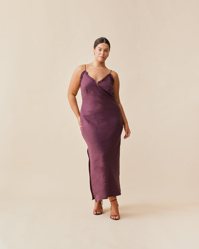 DELILAH LINEN SLIP NEVE | Bias cut slip with a V-neckline, with ruffle detailing around the bust line, designed in a rich plum colour. This slip features bust shaping and a side split on one...