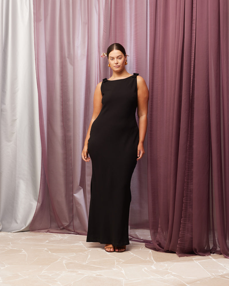 BLACK TIE GOWN BLACK BLACK | The iconic Black Tie Gown returns, in our signature firebird crepe. This gown features a bias cut, a plunging cowl back, and bow detailing at the shoulders. 
