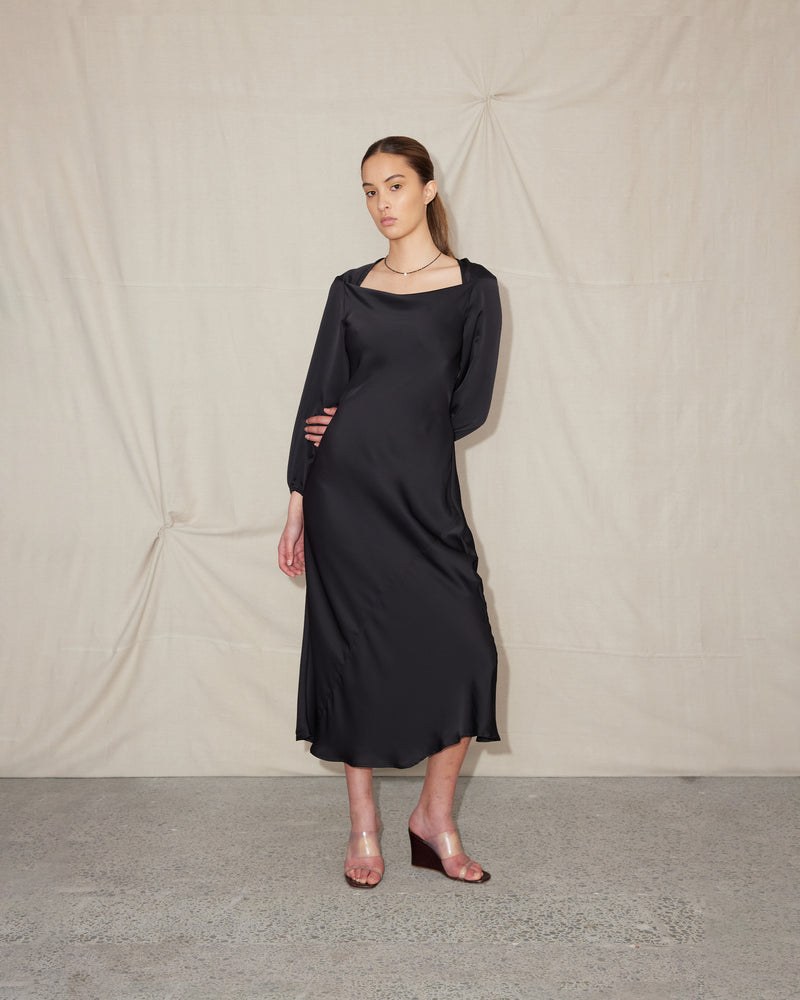  QUINCY MIDI DRESS BLACK | Long sleeve bias cut dress crafted in a luxe black satin. Features a wide boat style neckline that falls to give a soft cowl effect.