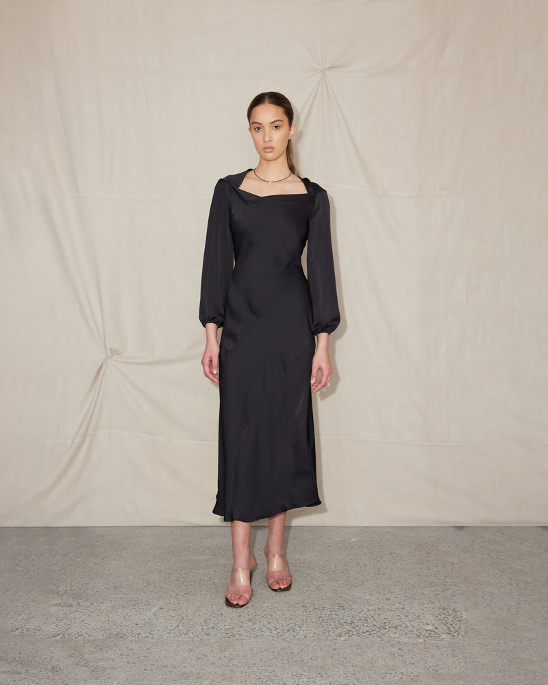 QUINCY MIDIDRESS BLACK | Long sleeve bias cut dress crafted in a luxe black satin. Features a wide boat-style neckline that falls to give a soft cowl effect.