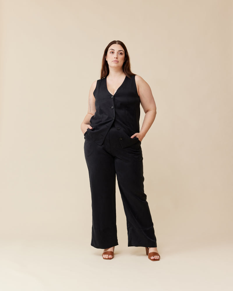 THELMA VEST BLACK | Long-line vest designed in a soft black cupro. Features panelling, a waist tie at the back and black buttons for a sleek look. This piece is versatile in that it...