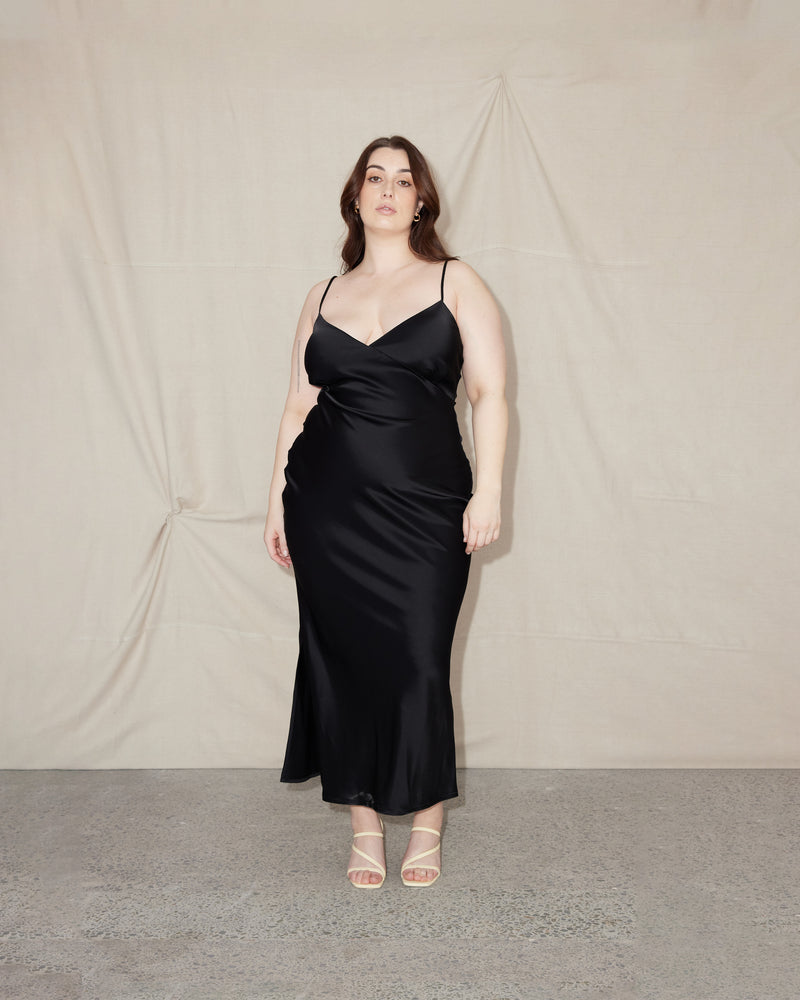 WEIRDLY SLIP BLACK | Iconic bias cut slip dress with plunging neckline in a new longer length. A wardrobe staple in heavy weight double satin that is lush to wear, in a sheeny black.