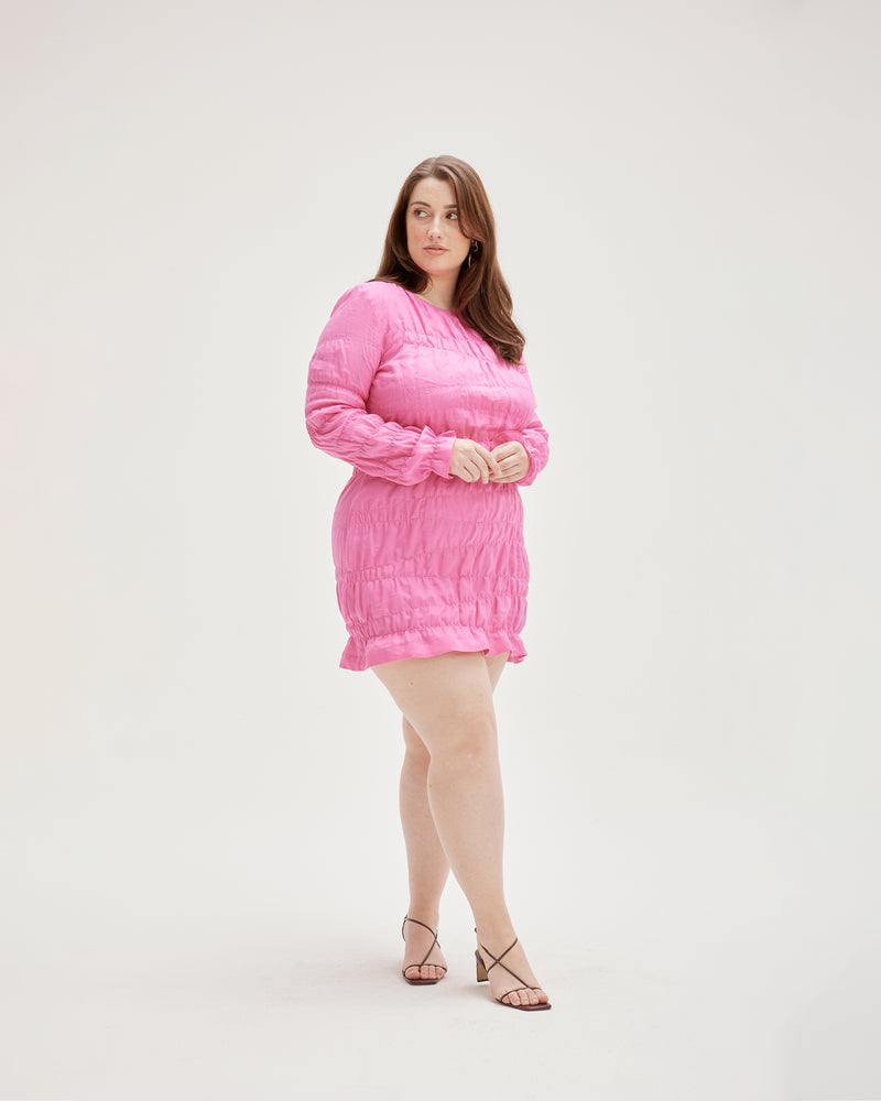 LILLIE MINIDRESS PINK | Elasticated longsleeve minidress with a frill hem, made in a delicate translucent pink coloured ramie voile. The elastic gathering throughout this dress creates a textured look that contrasts with the...