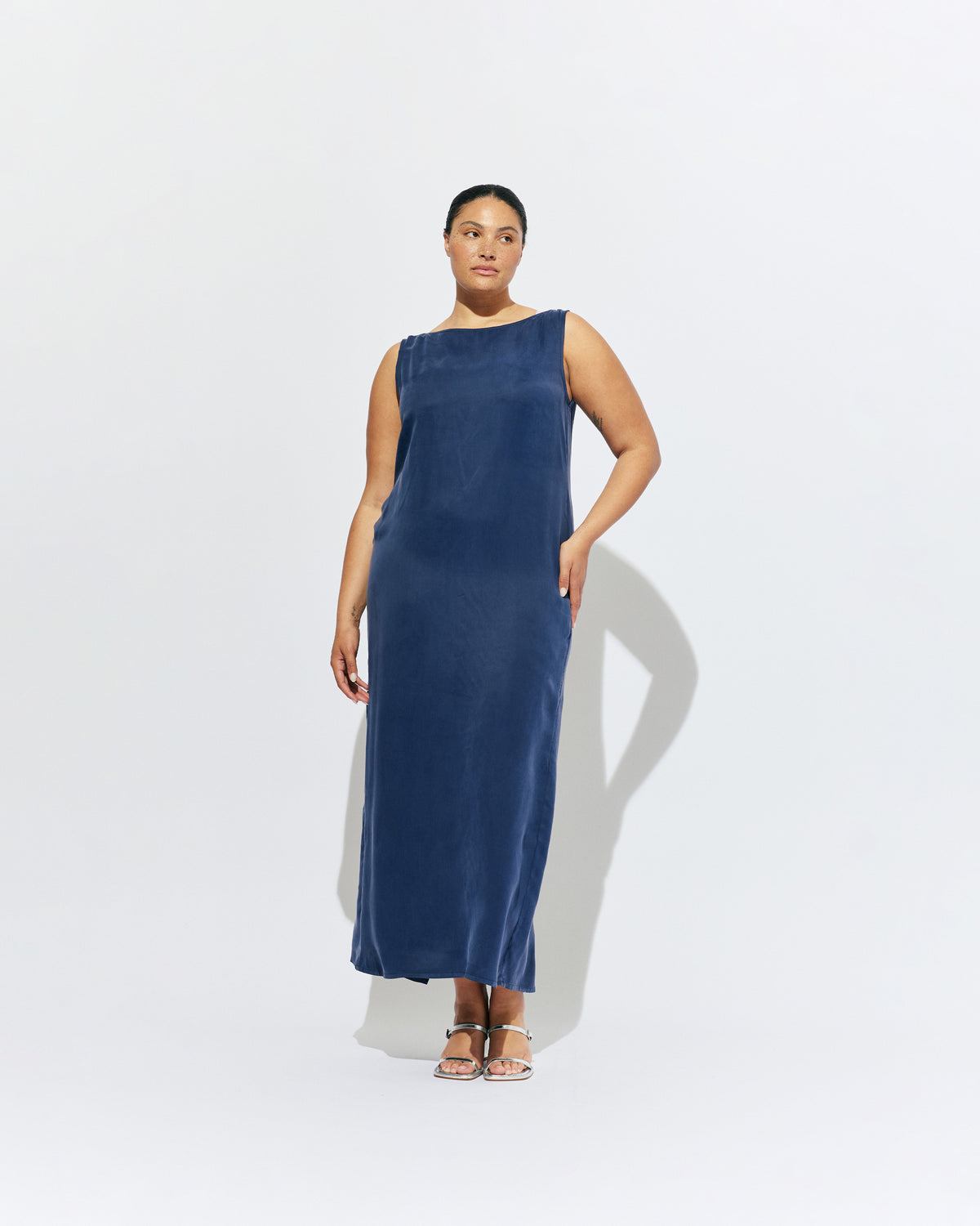 LIZ GOWN MULHOLLAND NAVY CUPRO | Liz is a relaxed fit sleeveless gown with a wrap feature, accentuated with long waist ties, that can be tied around the body or at the back in a bow. Imagined in a buttery soft navy magnolia cupro. 