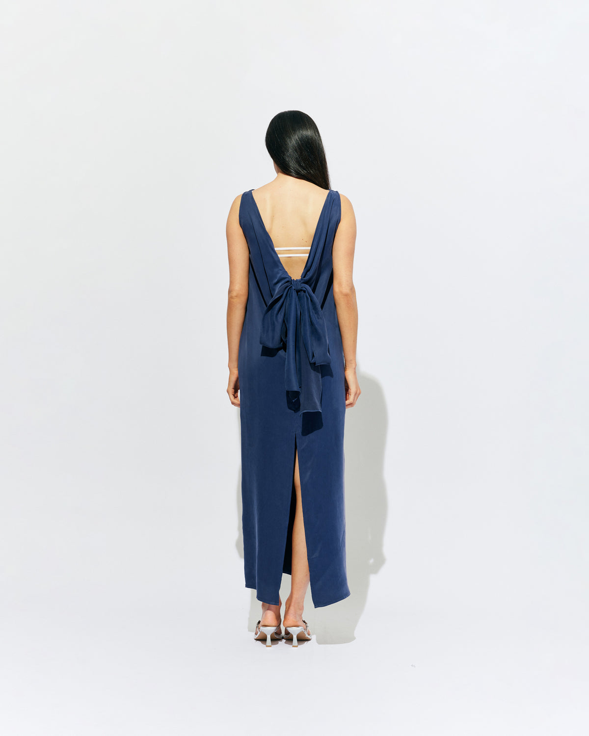 LIZ GOWN MULHOLLAND NAVY CUPRO | Liz is a relaxed fit sleeveless gown with a wrap feature, accentuated with long waist ties, that can be tied around the body or at the back in a bow. Imagined in a buttery soft navy magnolia cupro. 