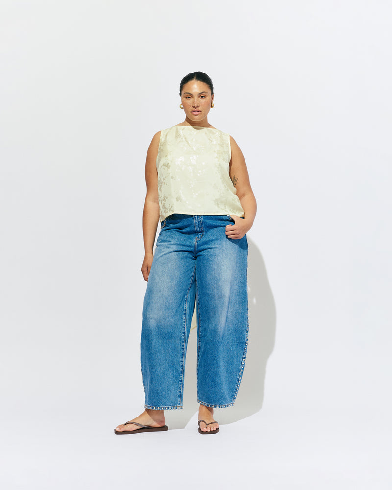 LIZ TOP BUTTER JACQUARD | Liz is a relaxed fit sleeveless top with a wrap feature, accentuated with long waist ties that can be tied around the body or at the back in a bow. Imagined in a sheeny jacquard satin, when this fabric catches...