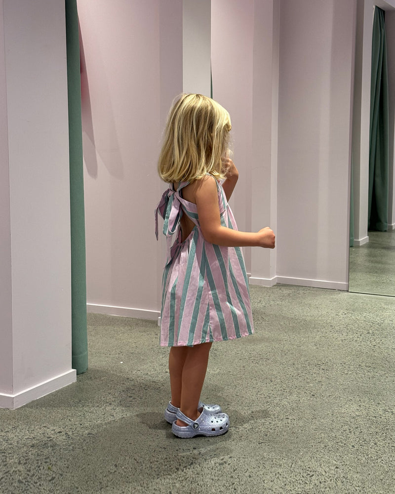 RUBÉBÉ MARGIE TIE MINI DRESS PINK APPLE STRIPE | One for our Rubébé's! Cotton mini dress with a square band at the chest. The skirt falls into an A-line shape with a bow tie closure at the back. Make...