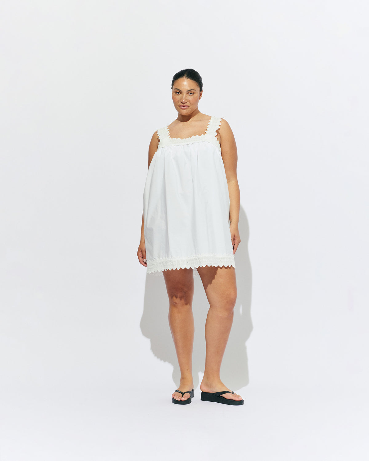 MARGIE LACE MINI DRESS WHITE | An update to our Margie Mini Dress crafted in a white organic cotton, with broderie detailing along the straps and across the bust. With a flowy silhouette through the body, this dress will keep you cute and cool in the...