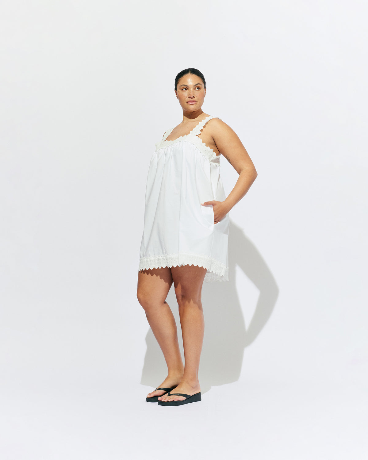 MARGIE LACE MINI DRESS WHITE | An update to our Margie Mini Dress crafted in a white organic cotton, with broderie detailing along the straps and across the bust. With a flowy silhouette through the body, this dress will keep you cute and cool in the...