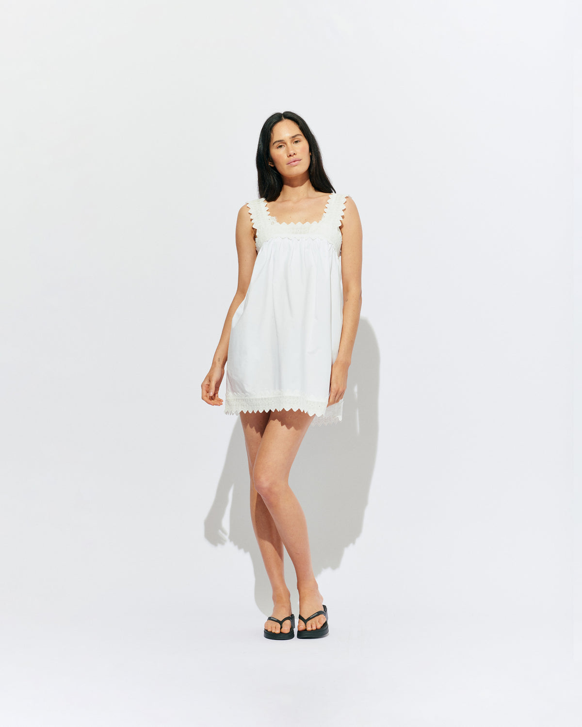MARGIE LACE MINI DRESS WHITE | An update to our Margie Mini Dress crafted in a white organic cotton, with broderie detailing along the straps and across the bust. With a flowy silhouette through the body, this dress will keep you cute and cool in the...