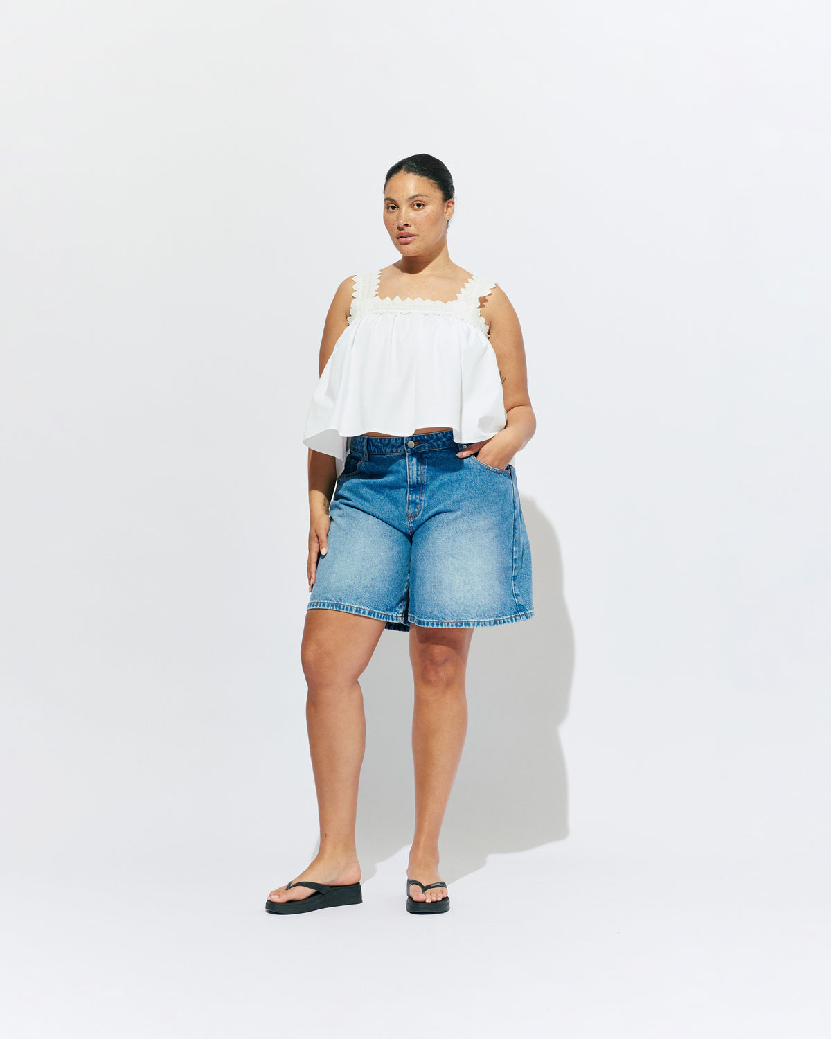 MARGIE LACE TOP WHITE | An update to our Margie Tie-back Top, this cami is crafted in a white organic cotton, with broderie detailing along the straps and across the bust. With a flowy silhouette through the body, this top will keep you cute and...
