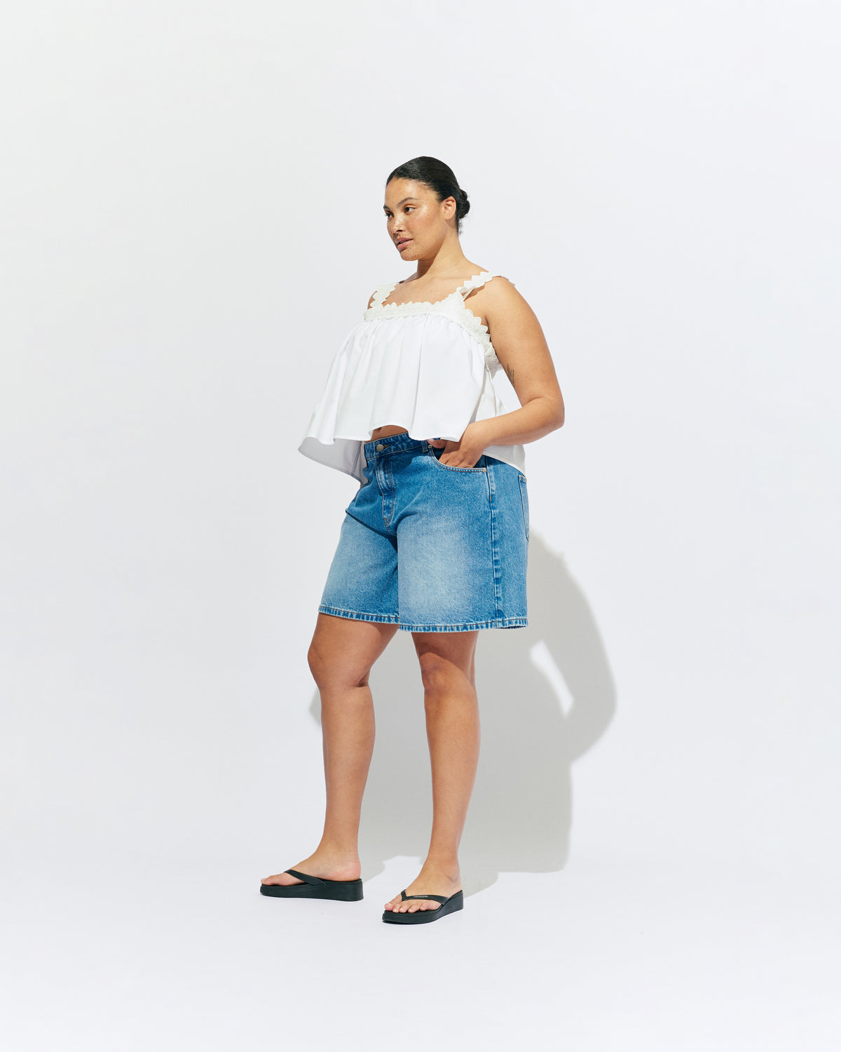 MARGIE LACE TOP WHITE | An update to our Margie Tie-back Top, this cami is crafted in a white organic cotton, with broderie detailing along the straps and across the bust. With a flowy silhouette through the body, this top will keep you cute and...