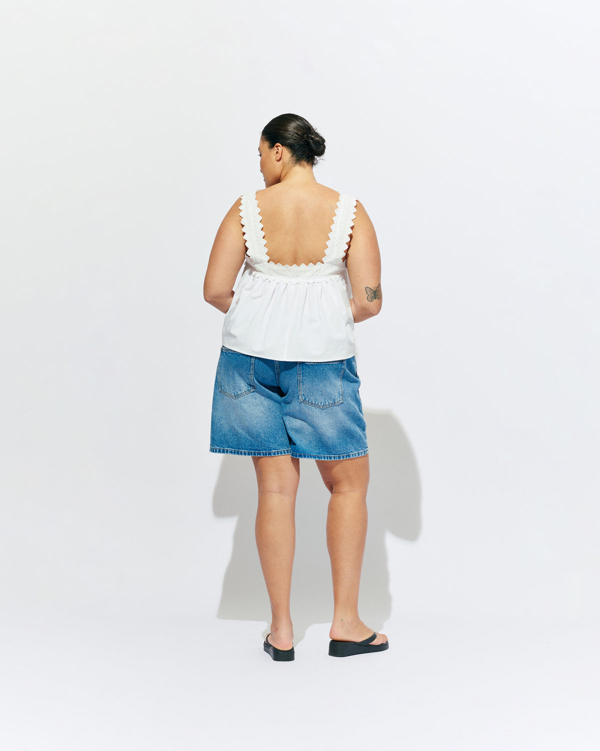 MARGIE LACE TOP WHITE | An update to our Margie Tie-back Top, this cami is crafted in a white organic cotton, with broderie detailing along the straps and across the bust. With a flowy silhouette through the body, this top will keep you cute and...