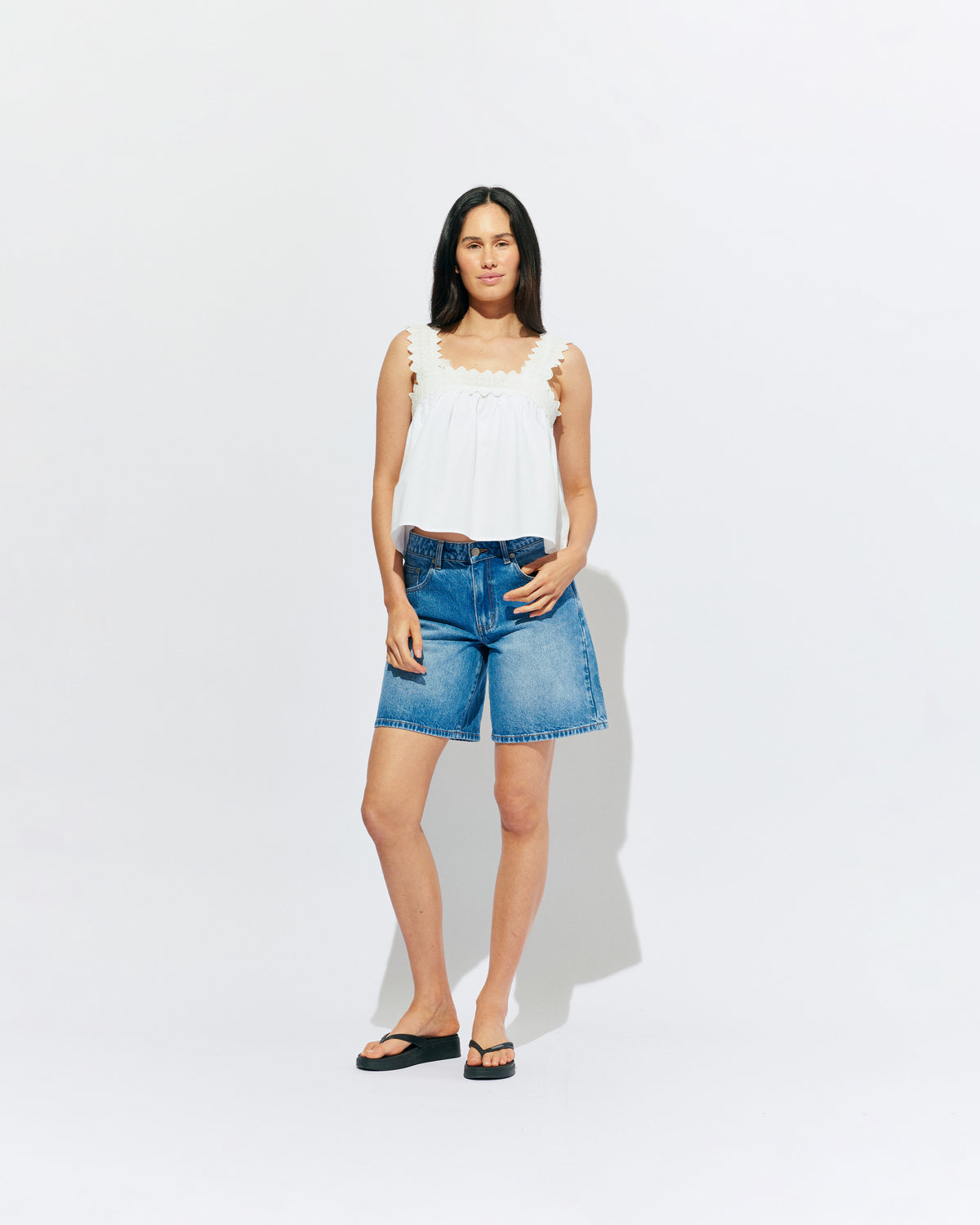 MARGIE LACE TOP WHITE | An update to our Margie Tie-back Top, this cami is crafted in a white organic cotton, with broderie detailing along the straps and across the bust. With a flowy silhouette through the body, this top will keep you cute and...