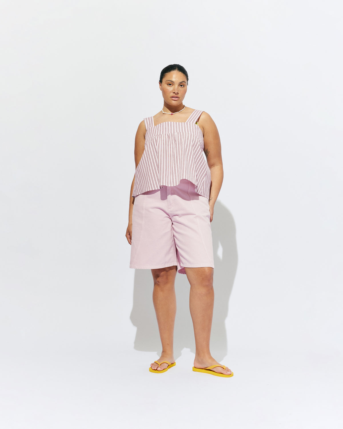 MARGIE TIE-BACK TOP PINK LADY STRIPE | Sleeveless organic cotton top with a square band at the bust, designed in our pink lady stripe. Features a bow tie detail at the back and a cut-out, this is the cutest summer top worn with your favourite denim.