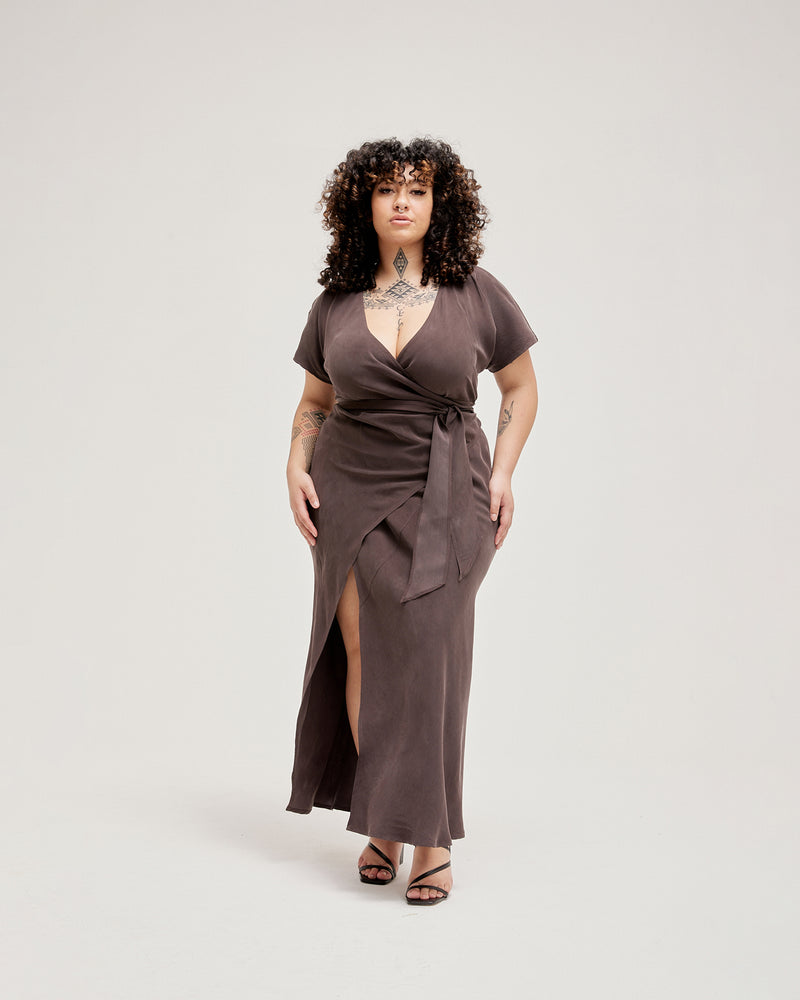 OMNIA CAPSLEEVE DRESS CHOCOLATE | Full length bias cut wrap dress cut from a lustrous chocolate cupro. This piece has cap sleeves and a front wrap panel that turns into the tie and continues to...