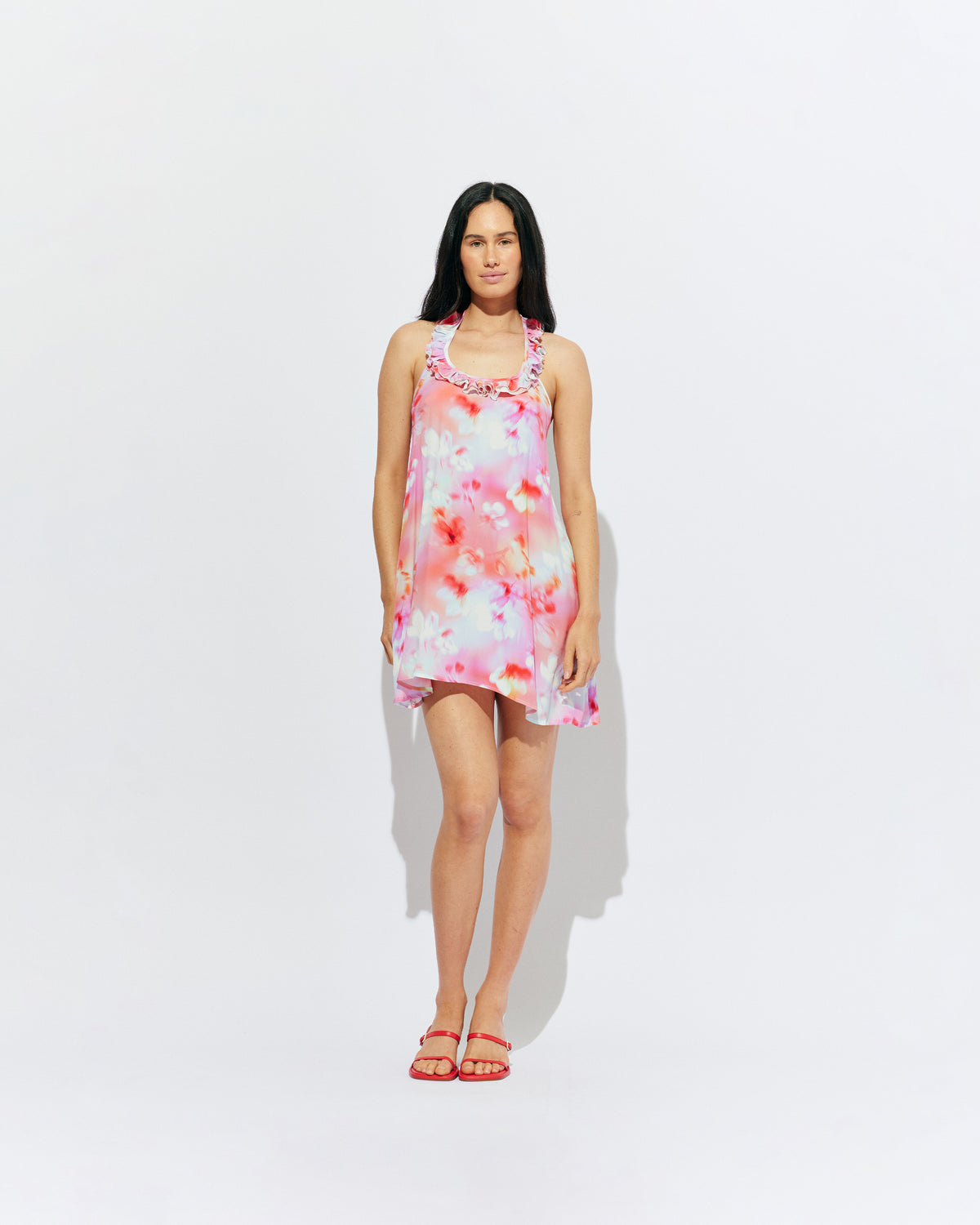 PASSIONFRUIT HALTER MINI DRESS GLOWY FLORAL | Floaty mini dress with feature ruffles along the neckline and an open back, designed in our glowy floral print. Features considered details with two side pockets and an adjustable tie at the neck, which make this an easy pick in...
