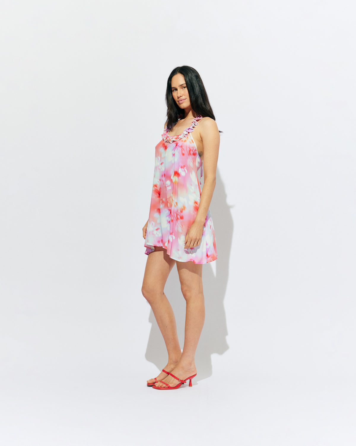 PASSIONFRUIT HALTER MINI DRESS GLOWY FLORAL | Floaty mini dress with feature ruffles along the neckline and an open back, designed in our glowy floral print. Features considered details with two side pockets and an adjustable tie at the neck, which make this an easy pick in...