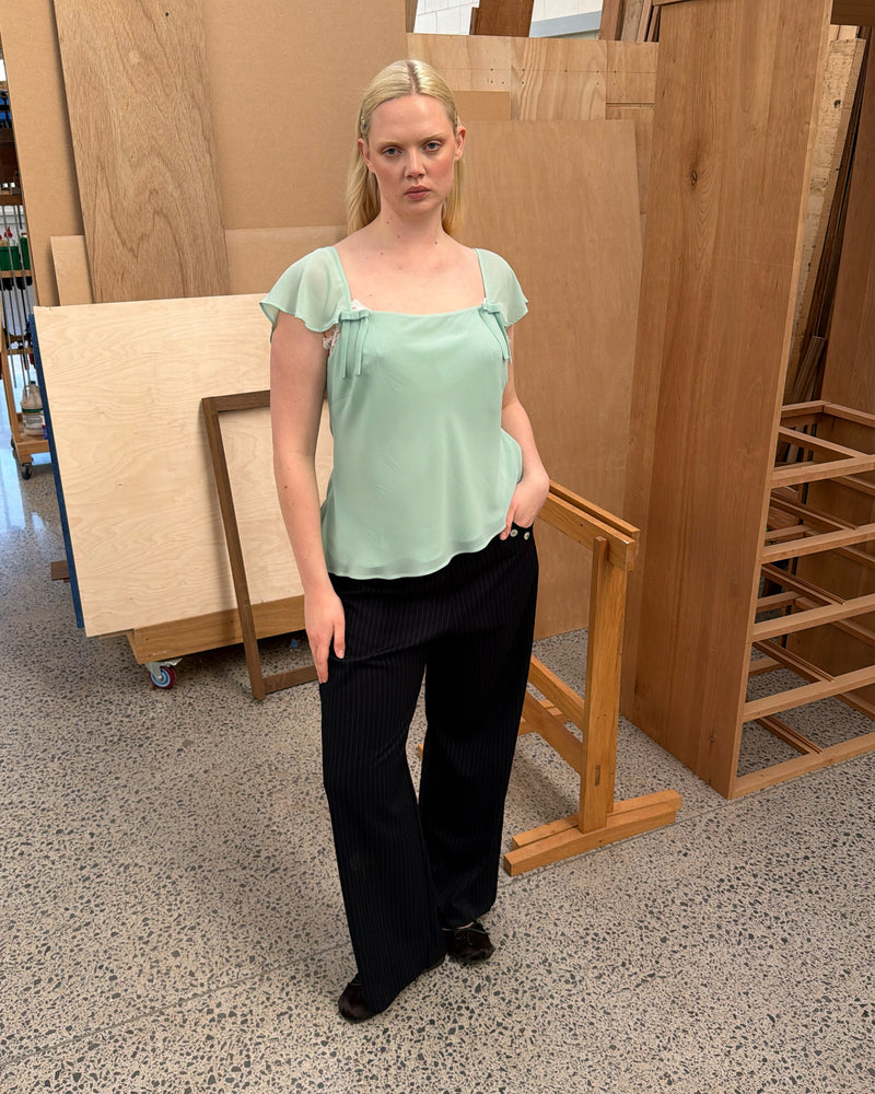 SABRINA CAMISOLE AQUAMARINE | Your new favourite top ~ the Sabrina Cami is designed in an aquamarine lightweight chiffon, with delicate cap sleeves, an asymmetrical hemline and bow detailing. Pair it with denim for the perfect evening plans outfit, or your favourite skirt for...